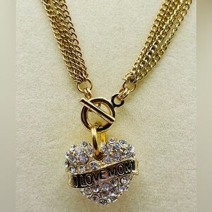 Rhinestone heart with “I love Mom” on the front on a multi chain necklace. Glam
